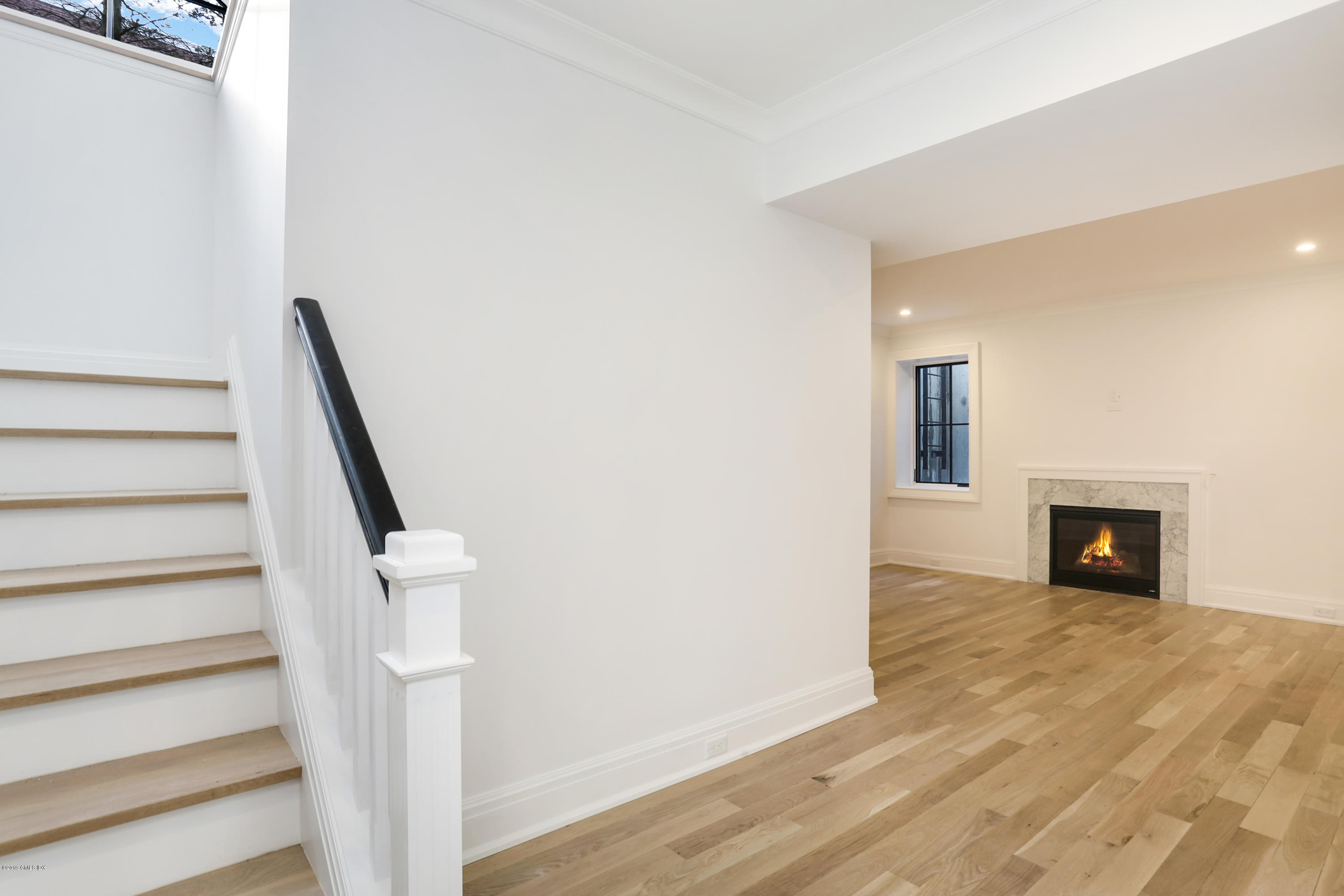 59 East Elm Street, Unit BACK Greenwich, CT 06830 - Photo 13 of 18 a view of an empty room with wooden floor and a fireplace