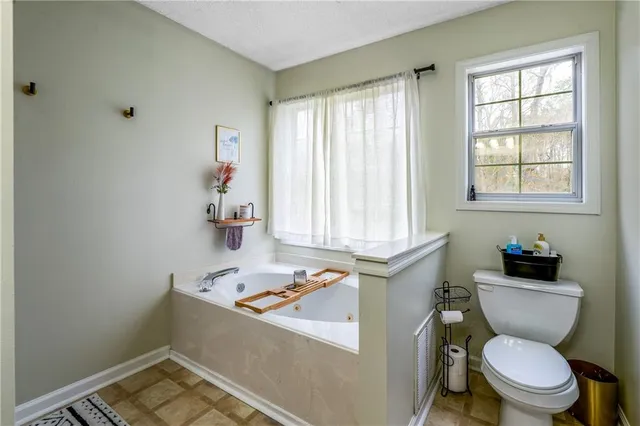 a bathroom with a sink toilet vanity and window