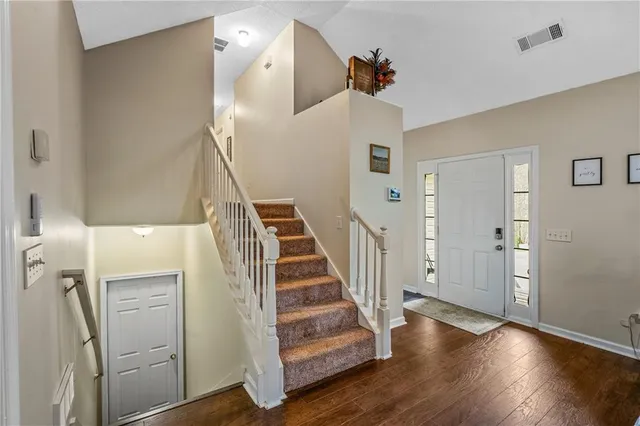 a view of a livingroom with wooden floor and stairs