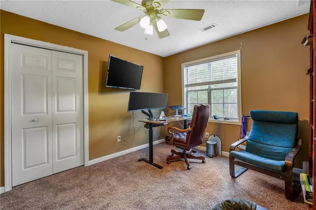 a living room with furniture a flat screen tv and a window