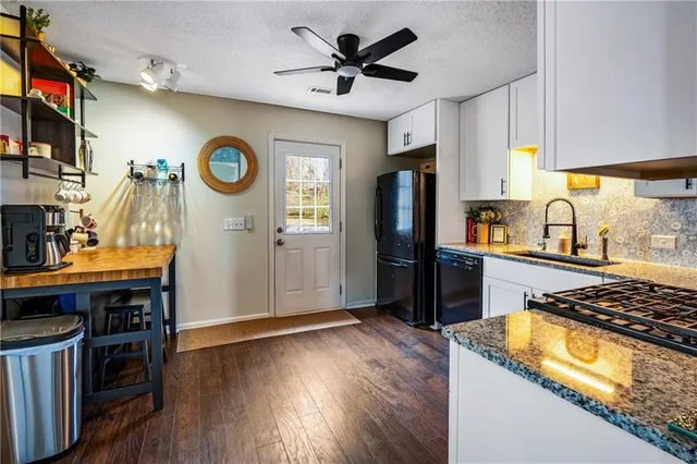 a kitchen with stainless steel appliances granite countertop a refrigerator and a stove top oven