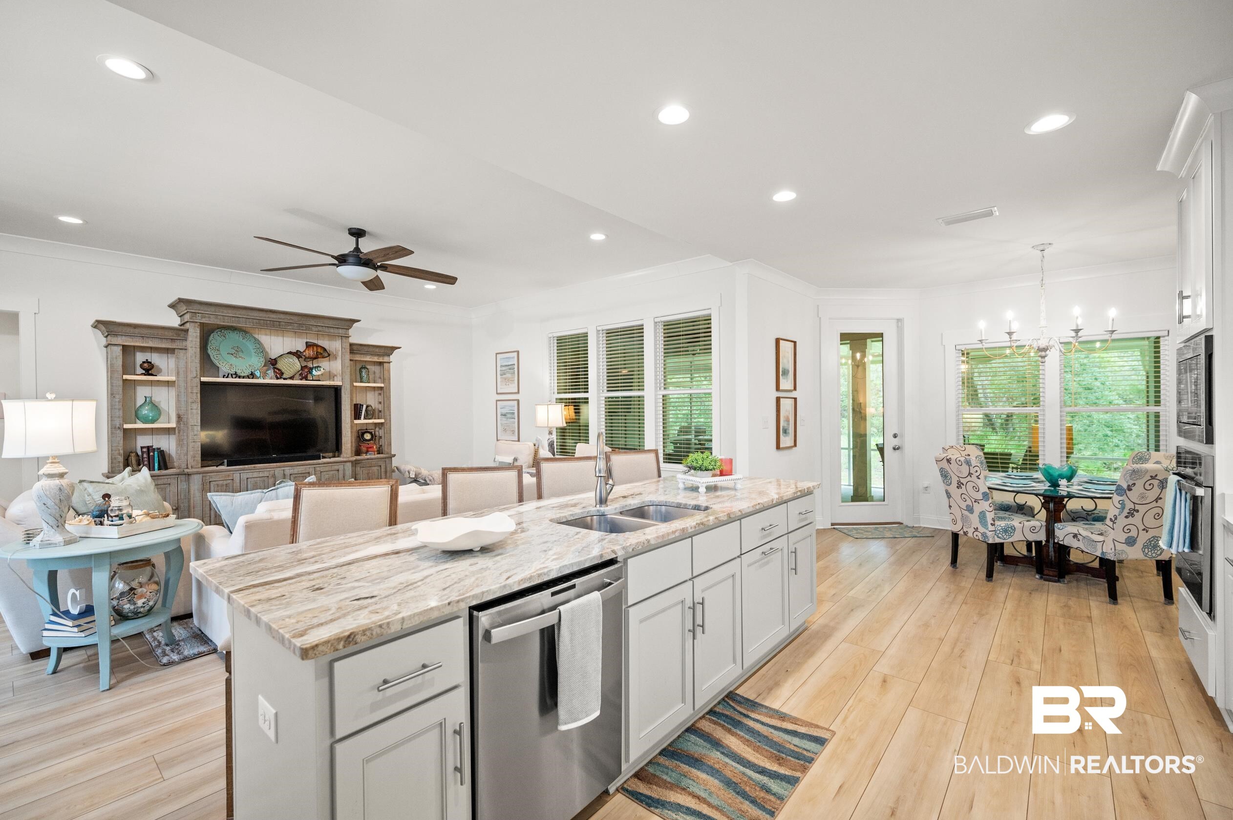 4601 Surrey Lane Orange Beach, AL 36561 - Photo 15 of 43 Kitchen with ceiling fan with notable chandelier, light hardwood / wood-style flooring, stainless steel appliances, sink, and a center island with sink