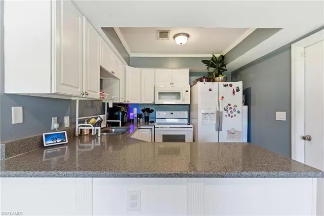a kitchen with kitchen island granite countertop a refrigerator a stove and a sink