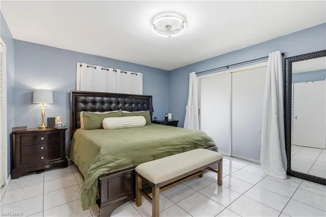 a bedroom with a bed and a lamp on dresser