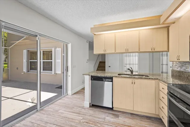 a kitchen with stainless steel appliances granite countertop a stove a sink and white cabinets