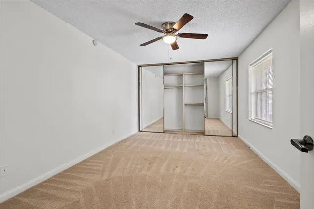 an empty room with closet and windows