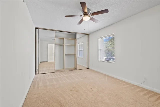 an empty room with closet and windows