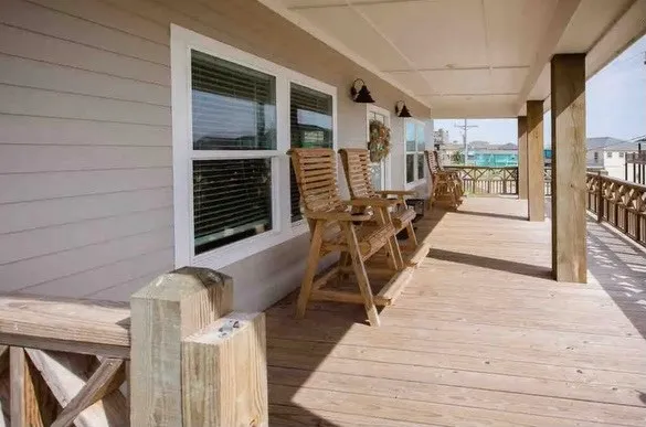a view of a patio with table and chairs with wooden floor and fence
