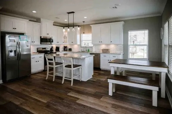 a kitchen with stainless steel appliances kitchen island wooden cabinets and dining table