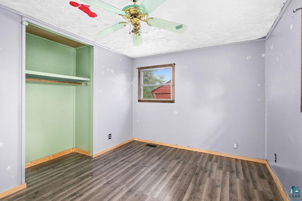 66 Banks Boulevard Silver Bay, MN 55614 - Photo 13 of 19 Unfurnished bedroom with dark wood-style floors, a closet, and ceiling fan