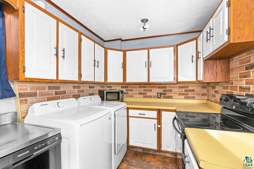 66 Banks Boulevard Silver Bay, MN 55614 - Photo 2 of 19 Laundry room featuring ornamental molding, washer and dryer, and dark stone finish floors