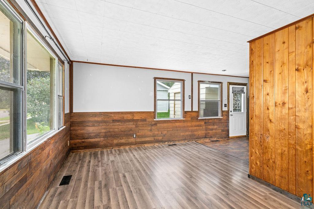 66 Banks Boulevard Silver Bay, MN 55614 - Photo 7 of 19 Unfurnished room with wood walls, wainscoting, wood finished floors, and ornamental molding