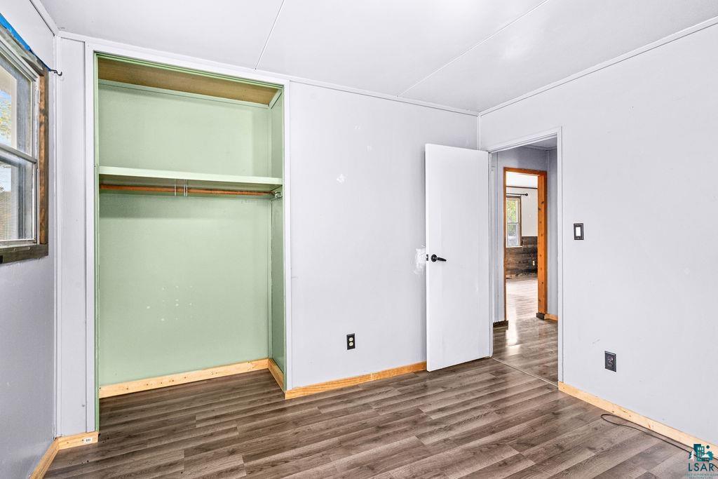 66 Banks Boulevard Silver Bay, MN 55614 - Photo 10 of 19 Unfurnished bedroom featuring dark wood-style flooring and a closet
