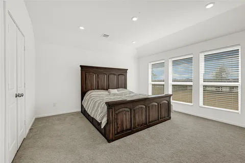 a spacious bedroom with a large bed and a large window