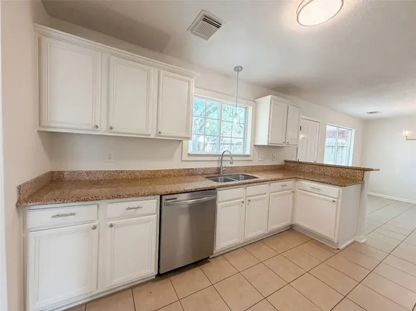 a kitchen with granite countertop white cabinets and white appliances