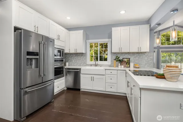 a kitchen with white cabinets stainless steel appliances and window