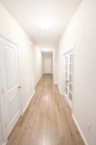 a view of a big room with wooden floor and windows