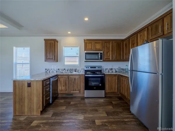 a kitchen with stainless steel appliances granite countertop a refrigerator stove and sink
