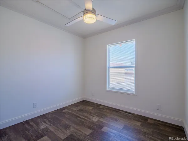 an empty room with wooden floor and a window