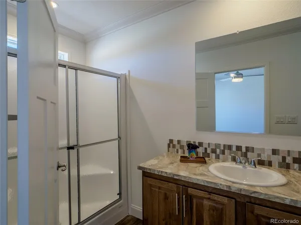 a bathroom with a granite countertop sink shower mirror and toilet