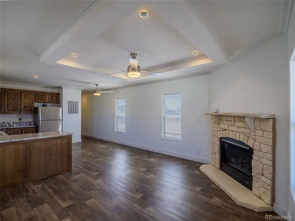 a view of a livingroom with wooden floor and a fireplace
