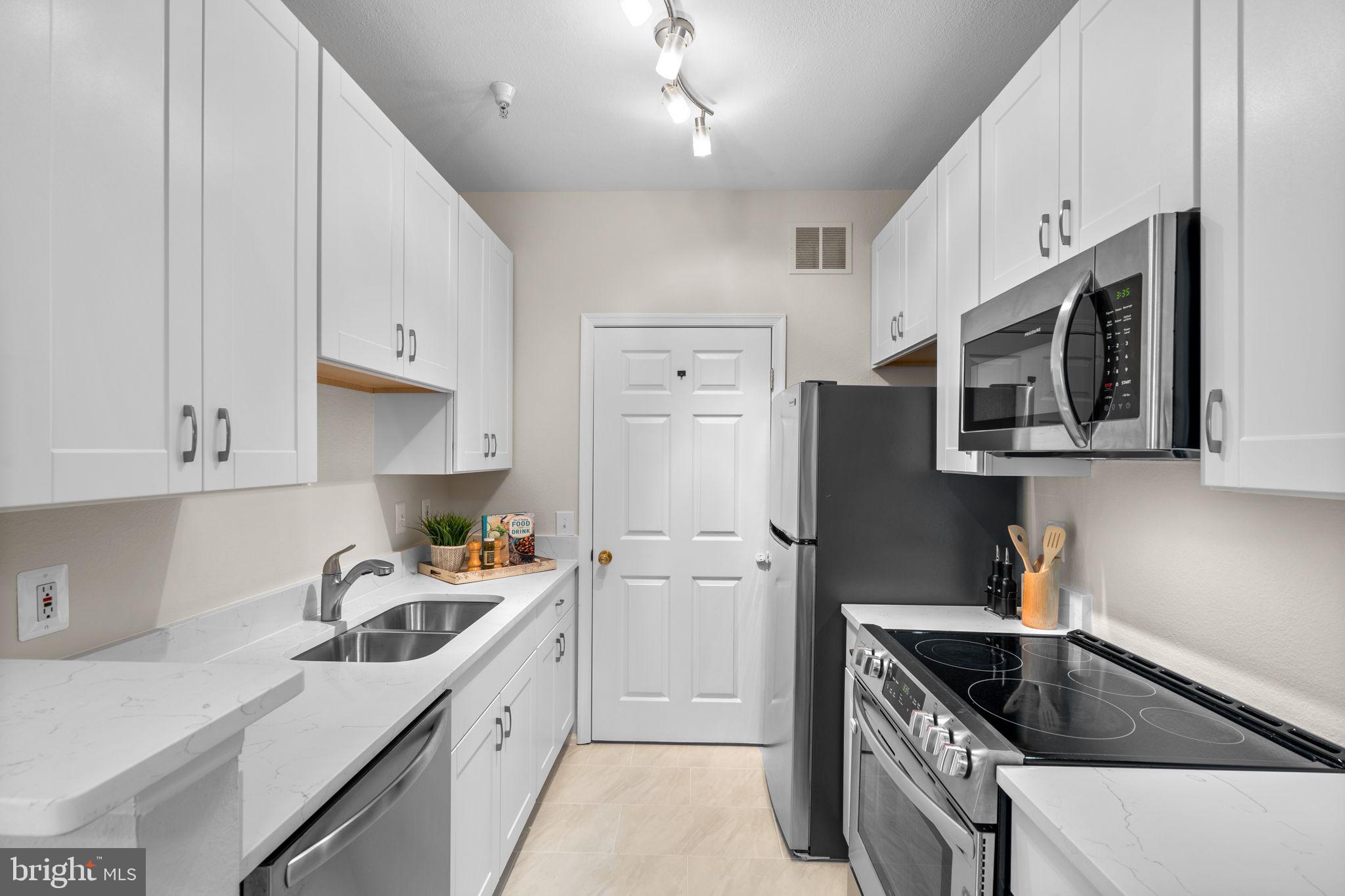 1570 Spring Gate Dr., Unit 7303 McLean, VA 22102 - Photo 11 of 25 a kitchen with stainless steel appliances granite countertop a sink stove and refrigerator