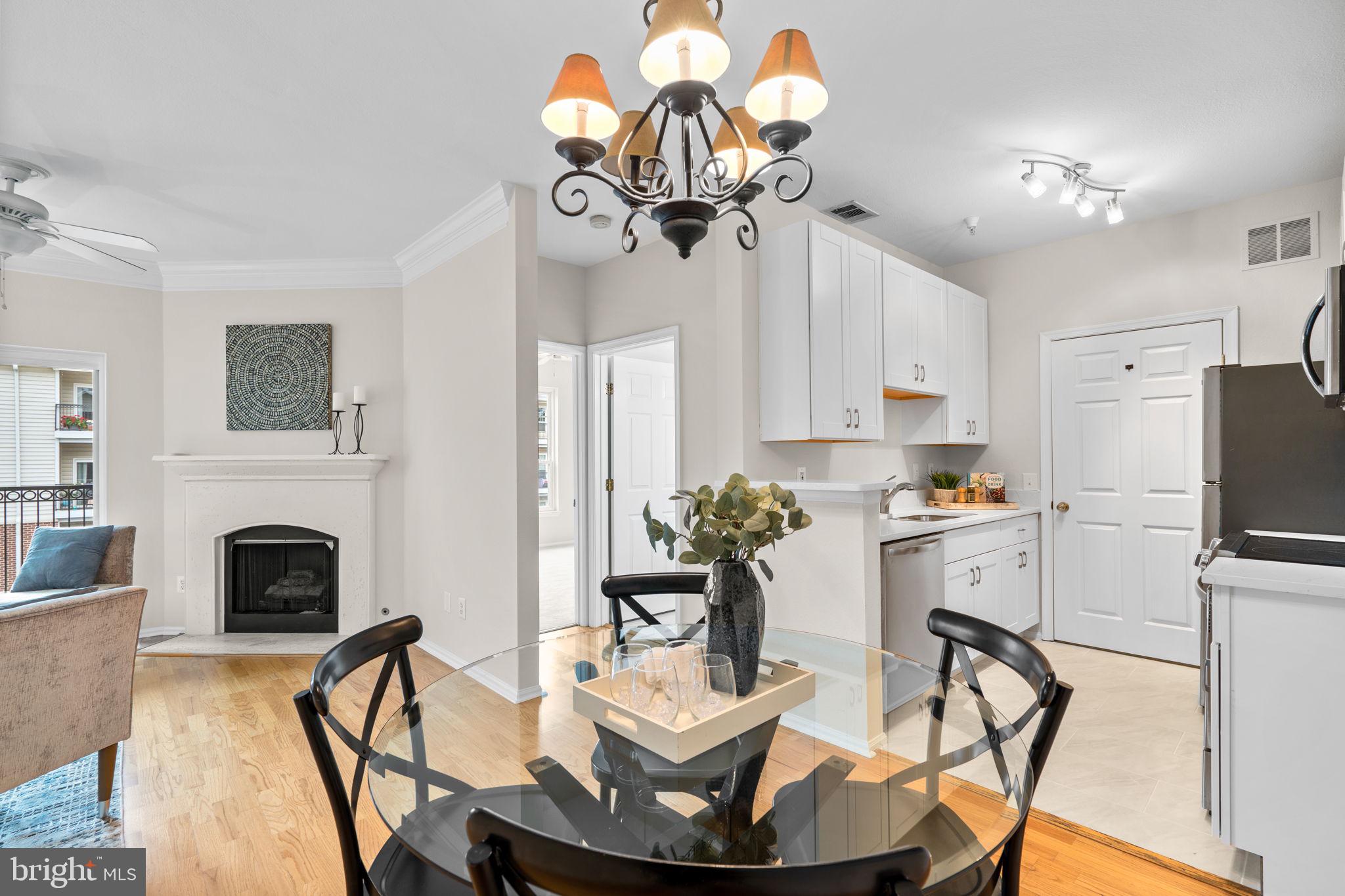 1570 Spring Gate Dr., Unit 7303 McLean, VA 22102 - Photo 9 of 25 a living room with furniture a fireplace and chandelier