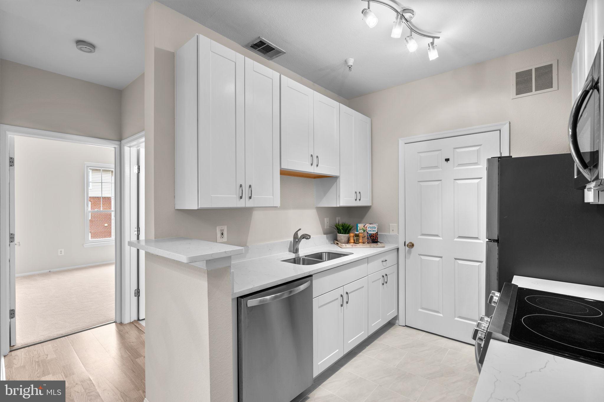 1570 Spring Gate Dr., Unit 7303 McLean, VA 22102 - Photo 10 of 25 a kitchen with white cabinets and white appliances