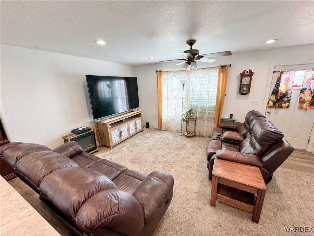 15333 South Doc Holliday Road Yucca, AZ 86438 - Photo 3 of 15 Carpeted living area with ceiling fan, a textured ceiling, and recessed lighting