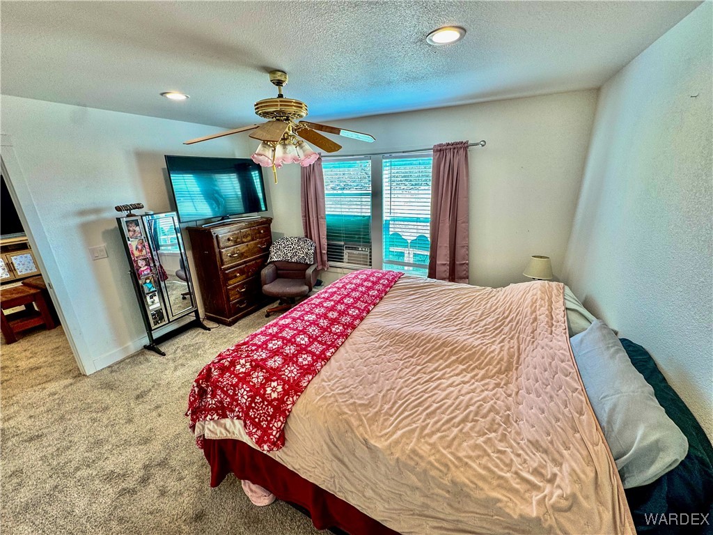 15333 South Doc Holliday Road Yucca, AZ 86438 - Photo 4 of 15 Carpeted bedroom featuring a ceiling fan, a textured ceiling, and baseboards