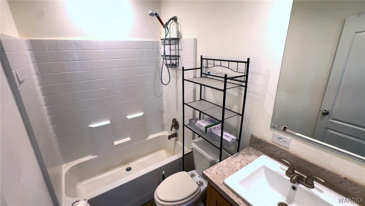 15333 South Doc Holliday Road Yucca, AZ 86438 - Photo 7 of 15 Bathroom with a textured wall, shower / washtub combination, vanity, and toilet