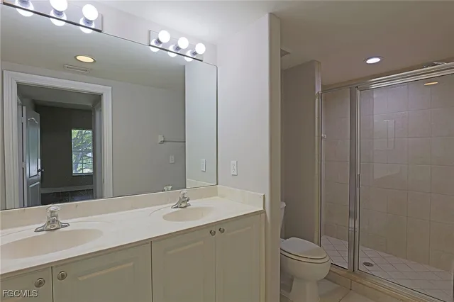 a bathroom with a double vanity sink toilet and a mirror