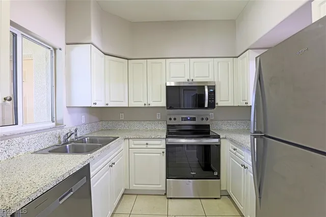 a kitchen with white cabinets sink and stainless steel appliances