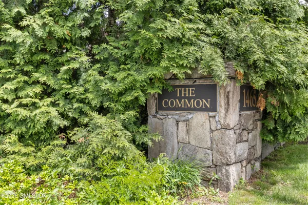 a sign that is sitting in front of a tree