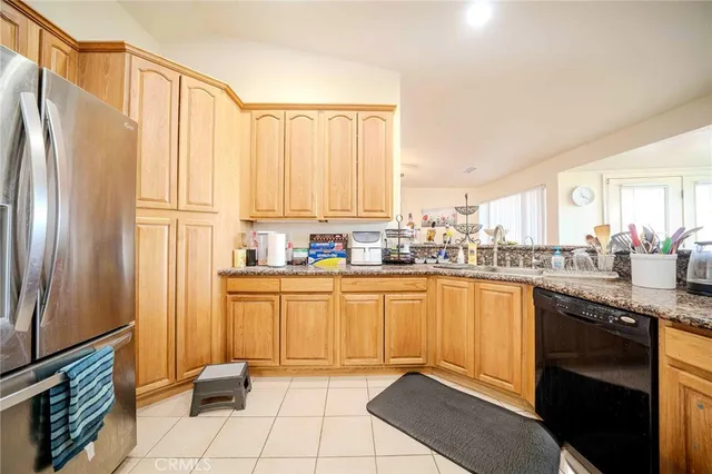 a kitchen with stainless steel appliances granite countertop a refrigerator and a stove top oven
