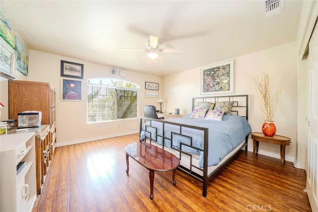 a bedroom with a bed and wooden floor