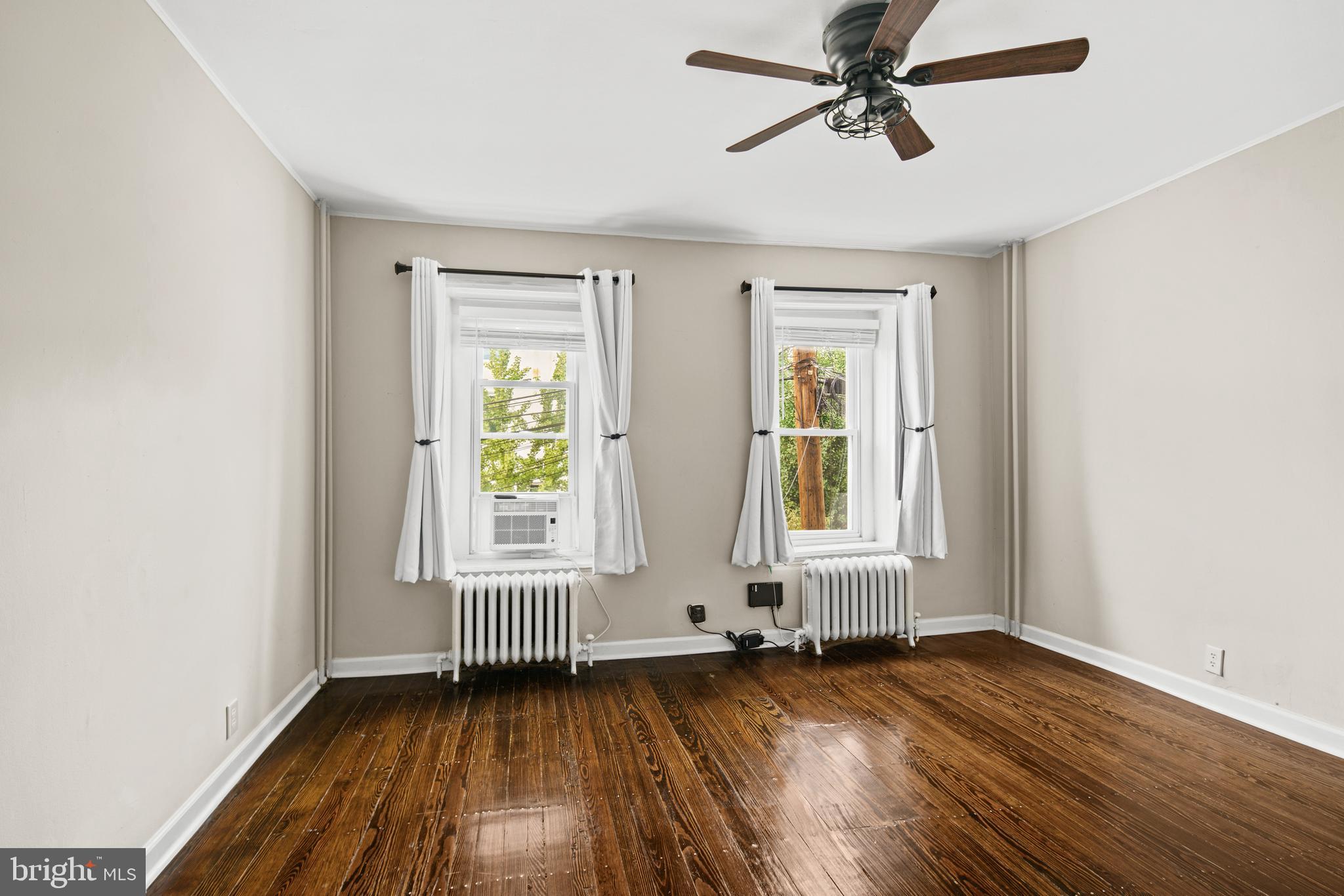 127 Seville Street Philadelphia, PA 19127 - Photo 12 of 23 an empty room with wooden floor windows and a ceiling fan