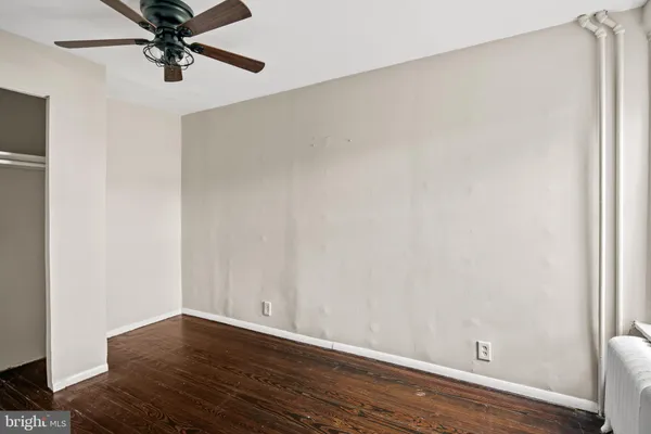a view of a livingroom with wooden floor and a ceiling fan