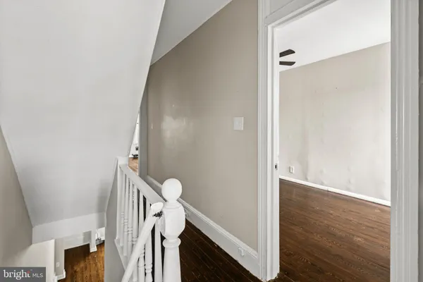 a view of a hallway with wooden floor and staircase