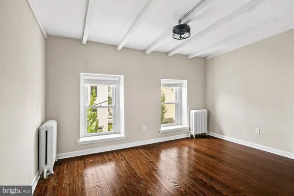 an empty room with windows and wooden floor