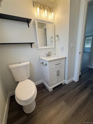a spacious bathroom with a toilet a sink and a mirror