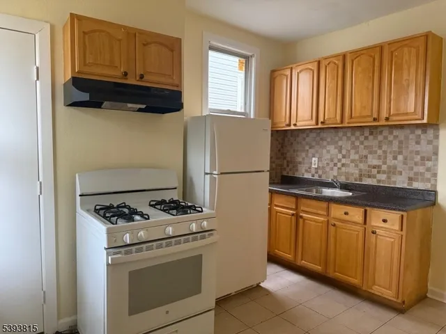a kitchen with stainless steel appliances granite countertop a stove a refrigerator and a sink