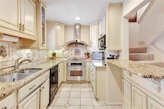 a kitchen with granite countertop a sink stainless steel appliances and cabinets