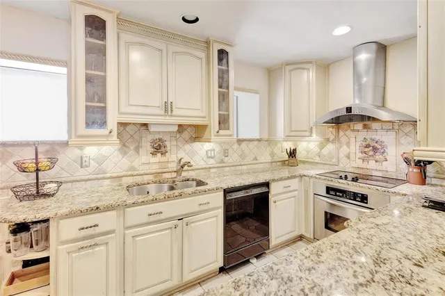 a kitchen with granite countertop a sink stainless steel appliances and cabinets