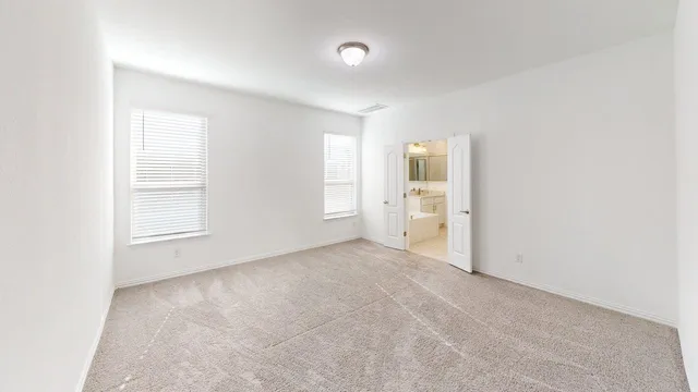 an empty room with closet and windows