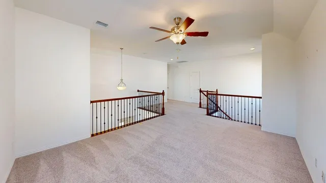 a view of a hallway with a ceiling fan and a window