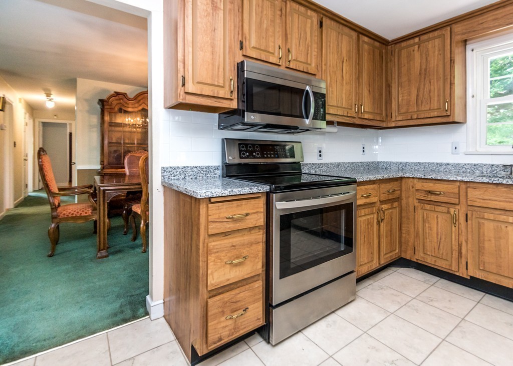 166 Totten Pond Road Waltham, MA 02451 - Photo 7 of 29 a kitchen with stainless steel appliances granite countertop a stove a sink and a microwave