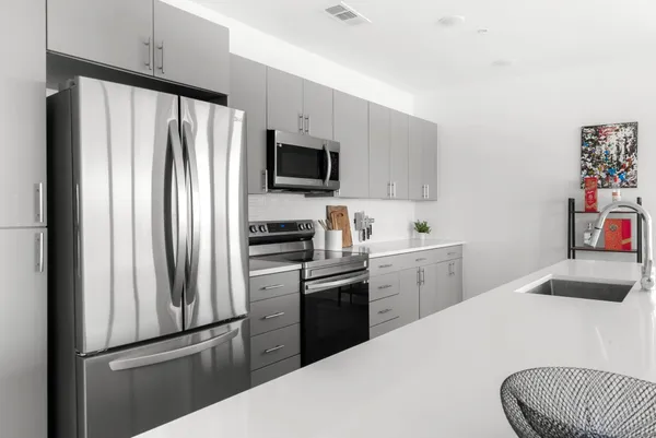 a kitchen with stainless steel appliances granite countertop a white cabinets and wooden floor