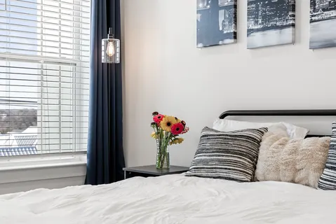 a spacious bedroom with a bed and a large window