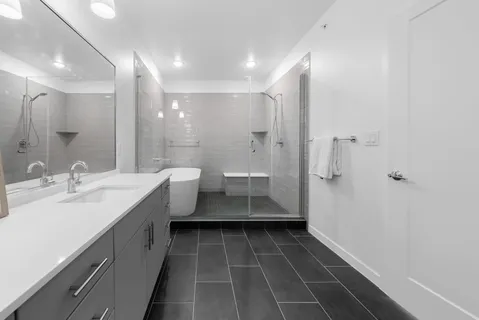 a spacious bathroom with a double vanity sink a mirror and a shower
